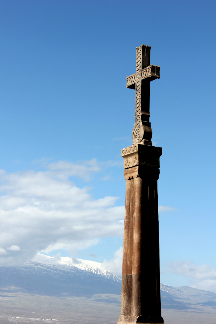 Monument cross against blue sky and mountains
