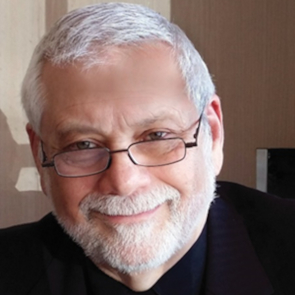 Edwin, black suit, glasses, slight smile